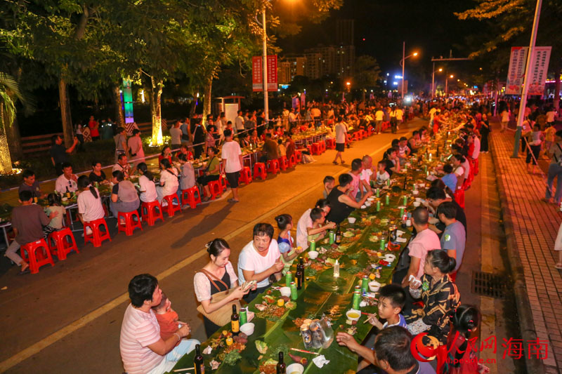 市民游客在長(zhǎng)桌宴上品嘗特色美食。人民網(wǎng) 牛良玉攝