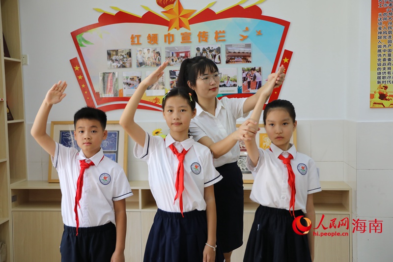 黃雨媚老師糾正同學(xué)行中國少年先鋒隊隊禮的姿勢。 人民網(wǎng)記者 孟凡盛攝