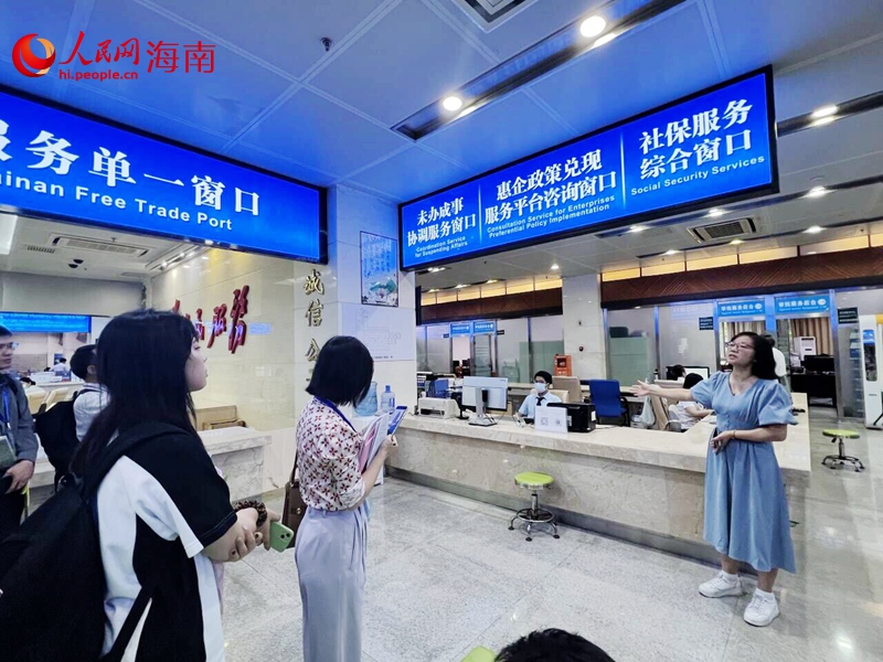 海南省政務(wù)大廳工作人員介紹窗口服務(wù)。人民網(wǎng)記者 李學(xué)山攝