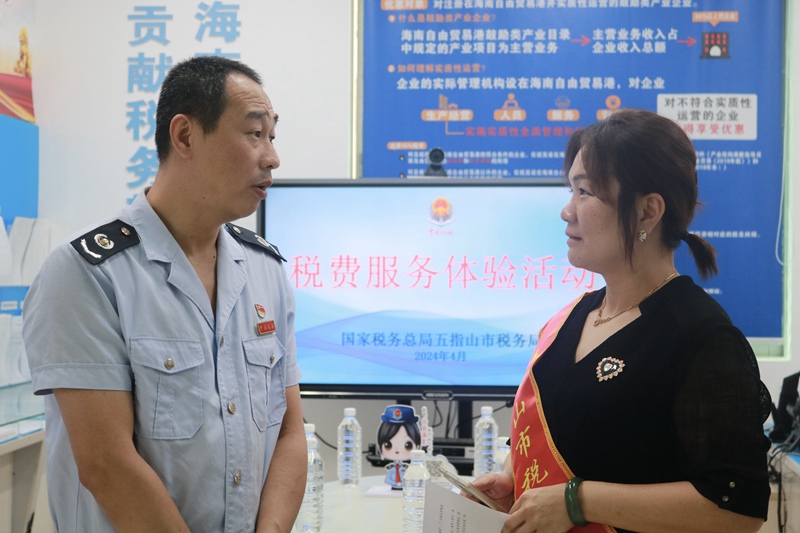 五指山市稅務(wù)局黨委委員、副局長(zhǎng)黃騰斌與五指山市市級(jí)政協(xié)委員李少娥親切交談，征集涉稅訴求。林家豪攝