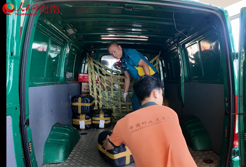 吳育仙將郵件搬運(yùn)裝車。人民網(wǎng)記者 李學(xué)山攝