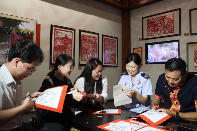 樂東企業(yè)代表與稅務(wù)干部圍繞稅收宣傳月主題進(jìn)行合作剪紙
