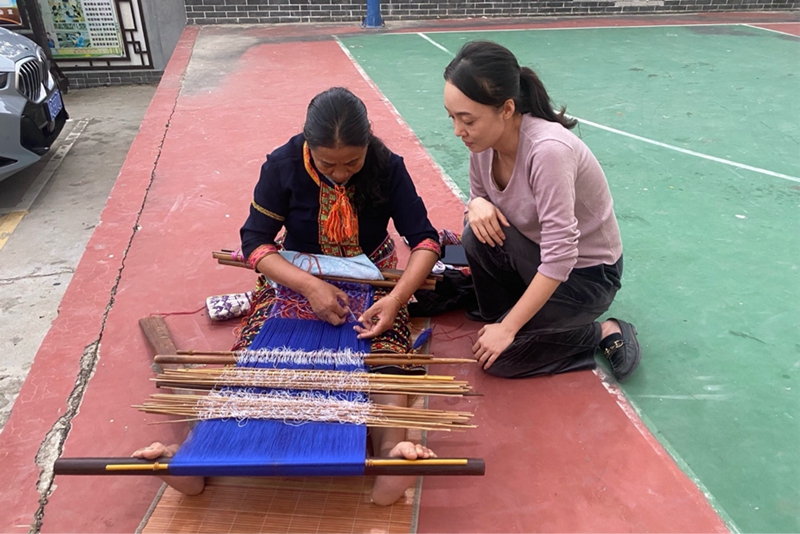 韋萬香席地而坐編織著黎錦。人民網(wǎng) 熊淑婷攝