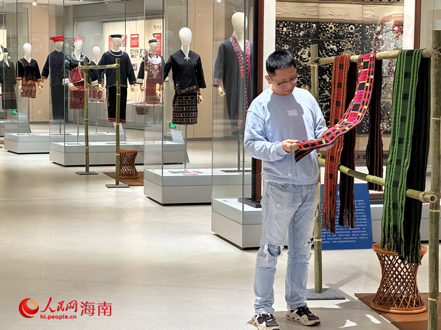 觀眾在“黎華錦簇——黎族傳統(tǒng)紡染織繡技藝保護成就展”親手觸摸黎錦的質(zhì)感。人民網(wǎng) 劉楊攝